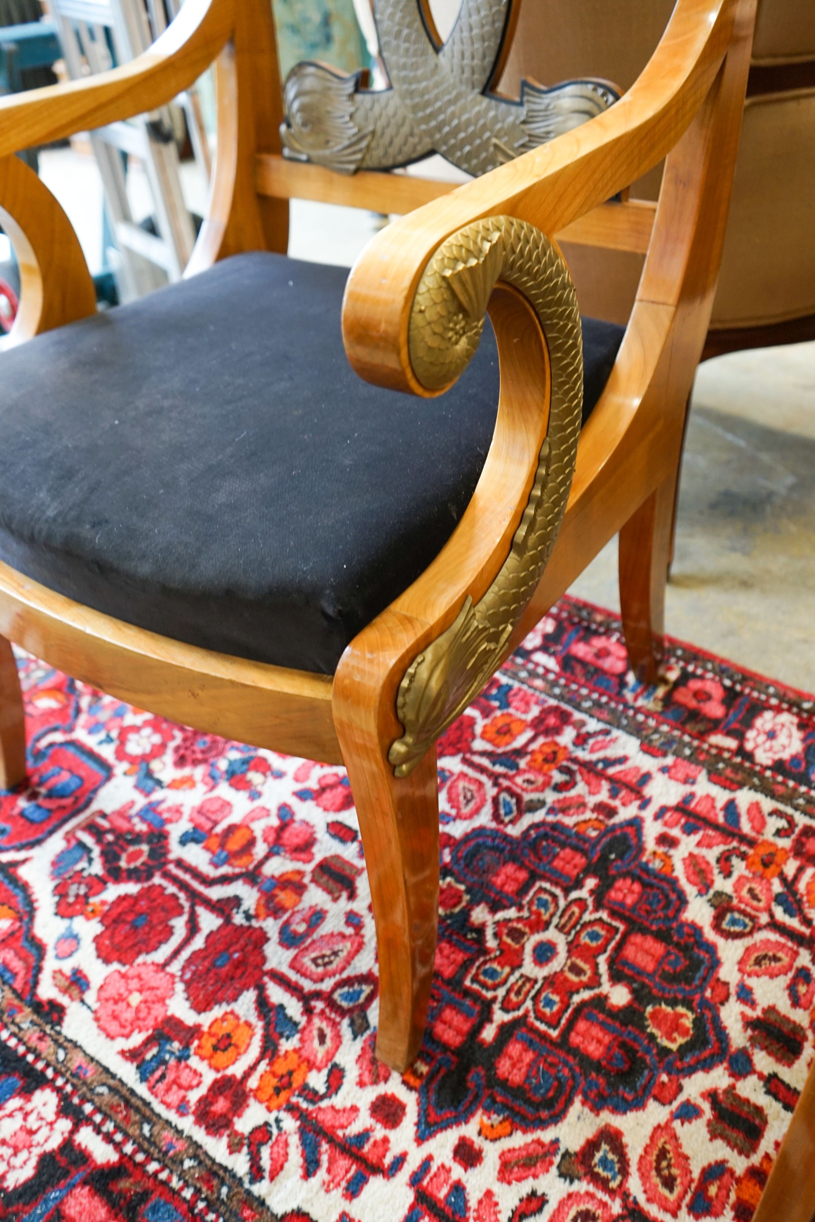 A pair of Empire style cherry elbow chairs with gilt metal dolphin mounts, width 65cm, depth 56cm, height 107cm
